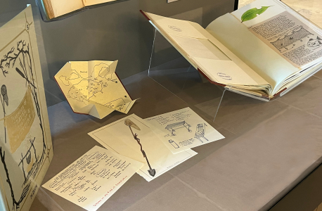 installation view of a book and various illustrated sheets