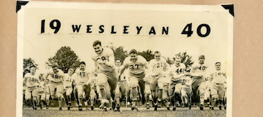 Archival black-and-white photograph from 1940 showing the Wesleyan football team charging forward across a grass field toward the camera.