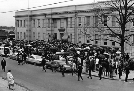 Crowd of people in front of a downtown building.