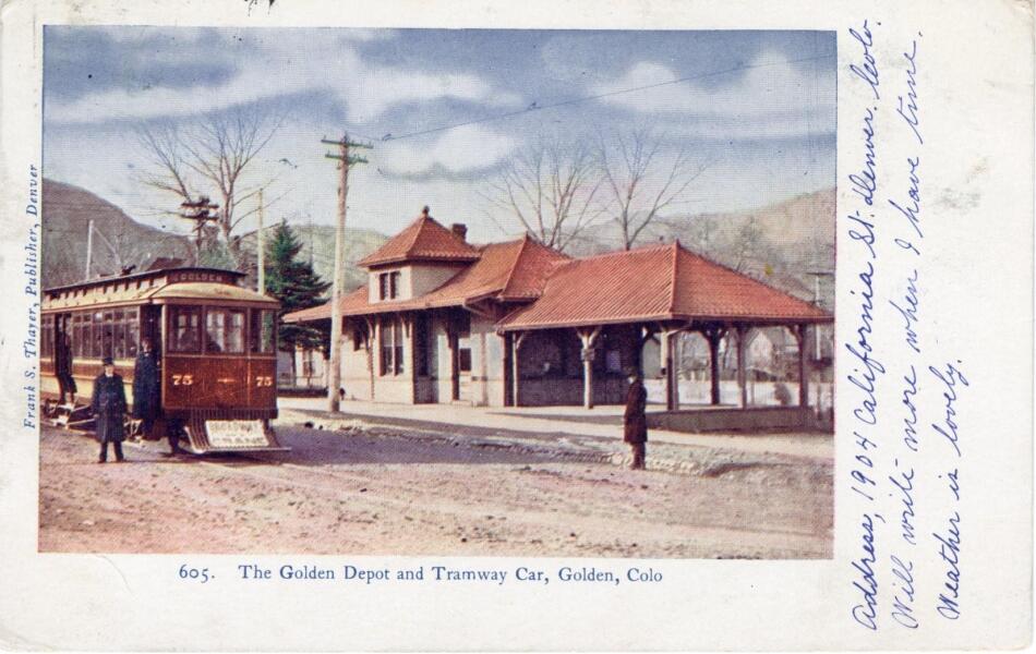 A colorized image of the Golden, Colorado Train Depot with a Tramway car and passengers. There's handwritten correspondence written up the side.