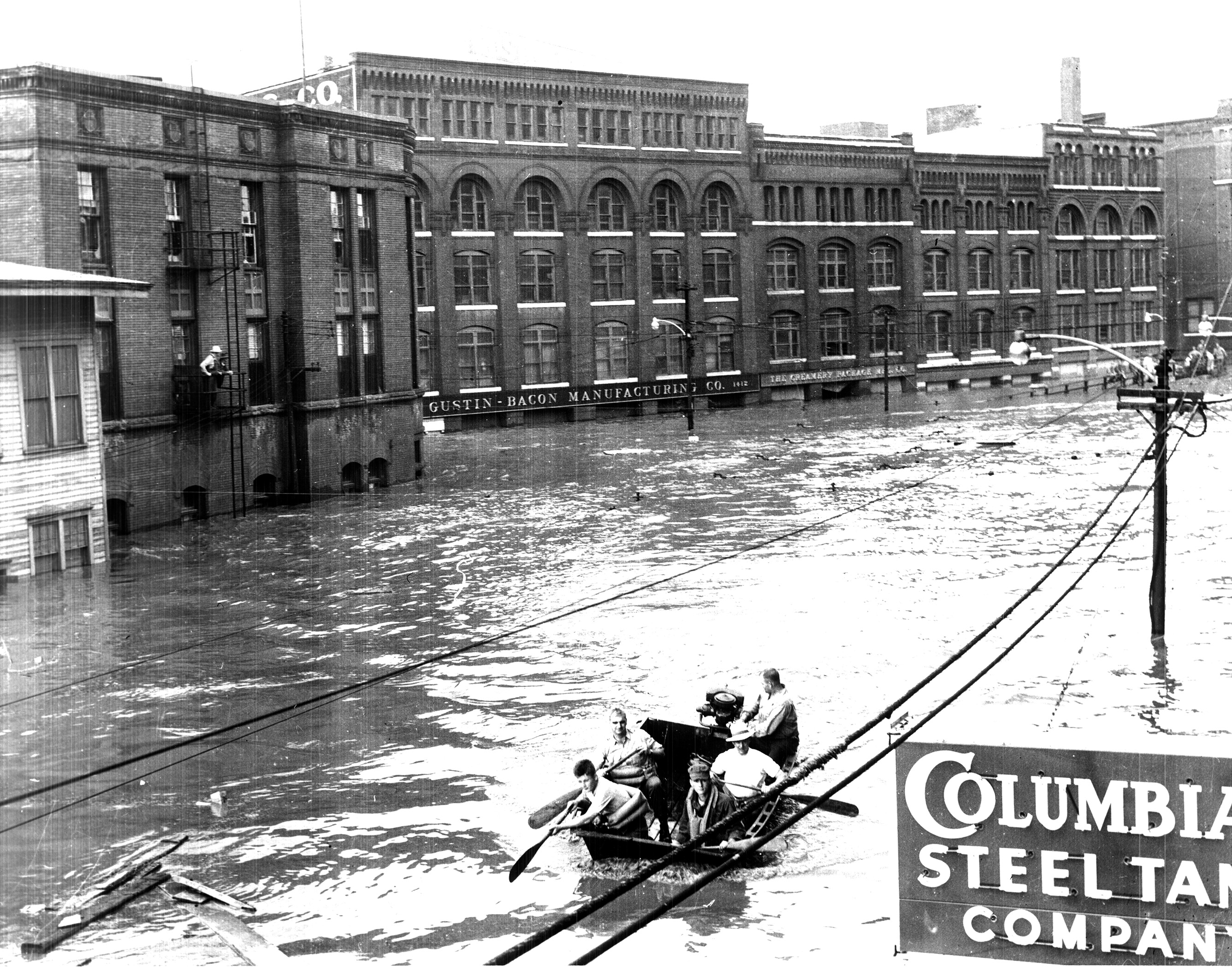A group of people in a rowboat on a flooded street