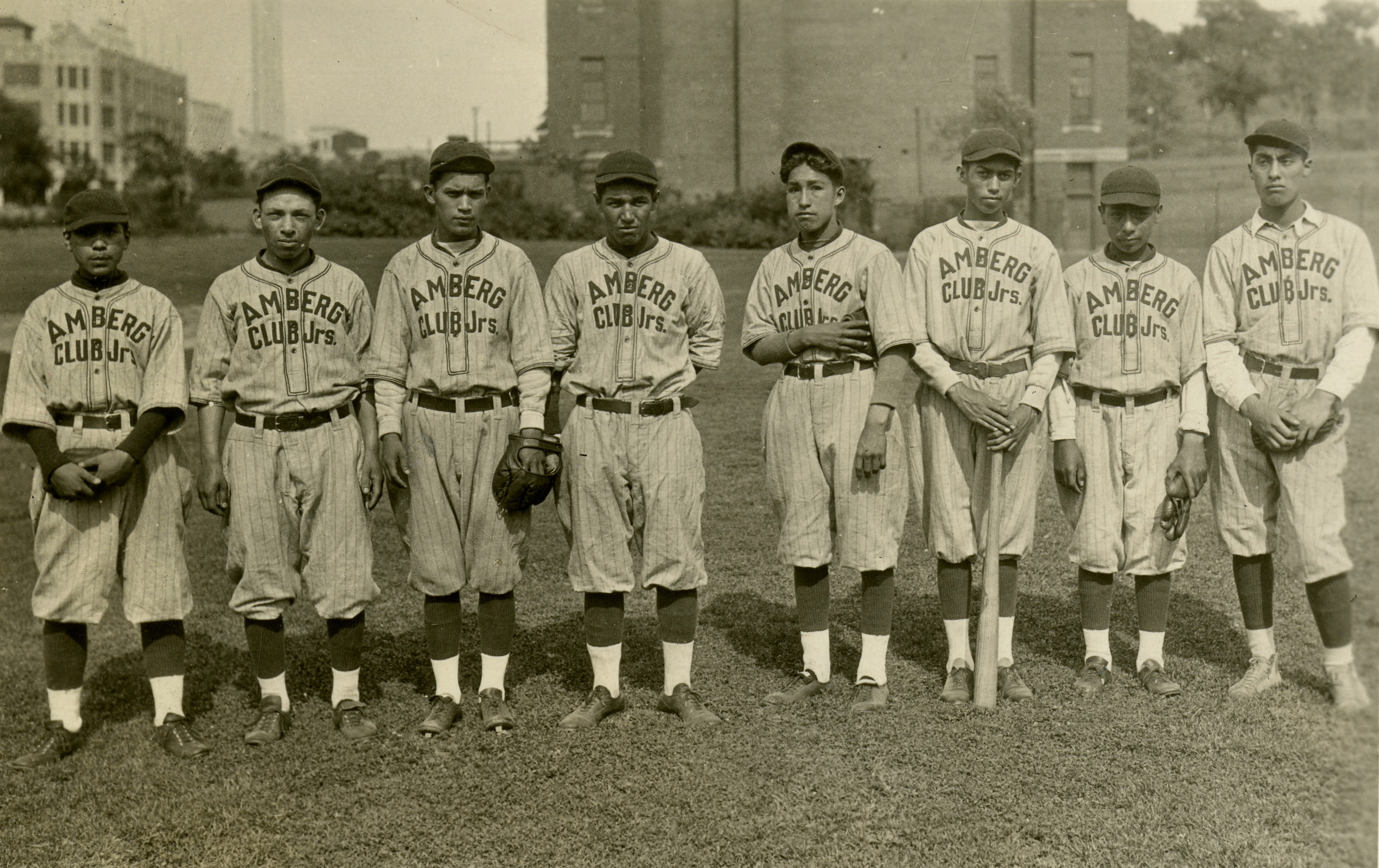 Eight men in baseball uniforms standing side by side in a line.