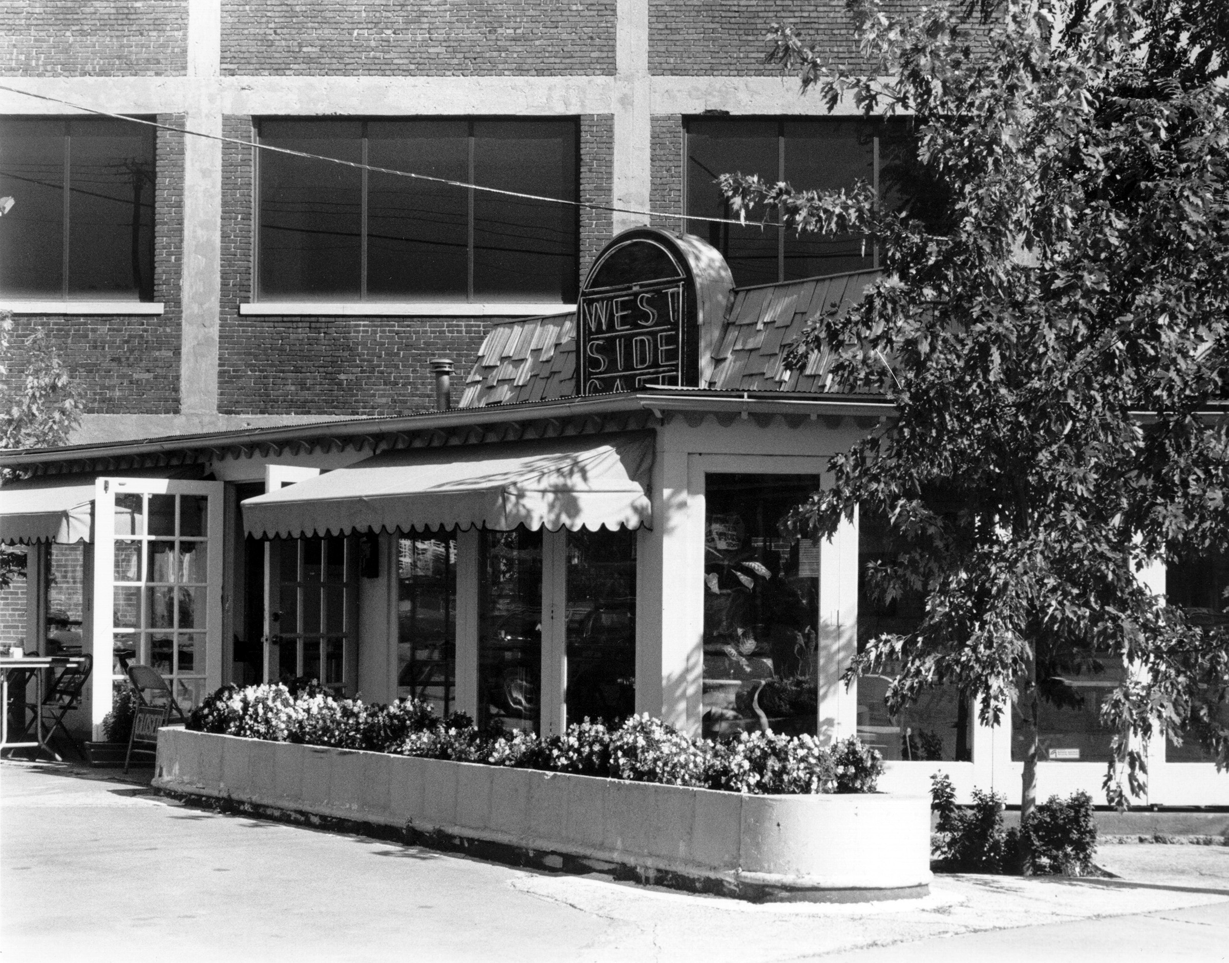 small, one-story building with planter outside. A sign on the roof reads "West Side"