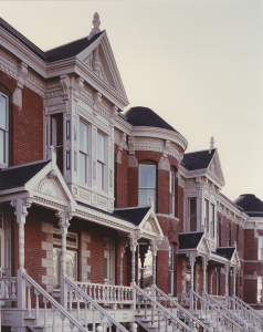 A series of Victorian-style row houses, viewed from the street