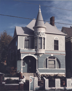 A gray Victorian-style house with a turret