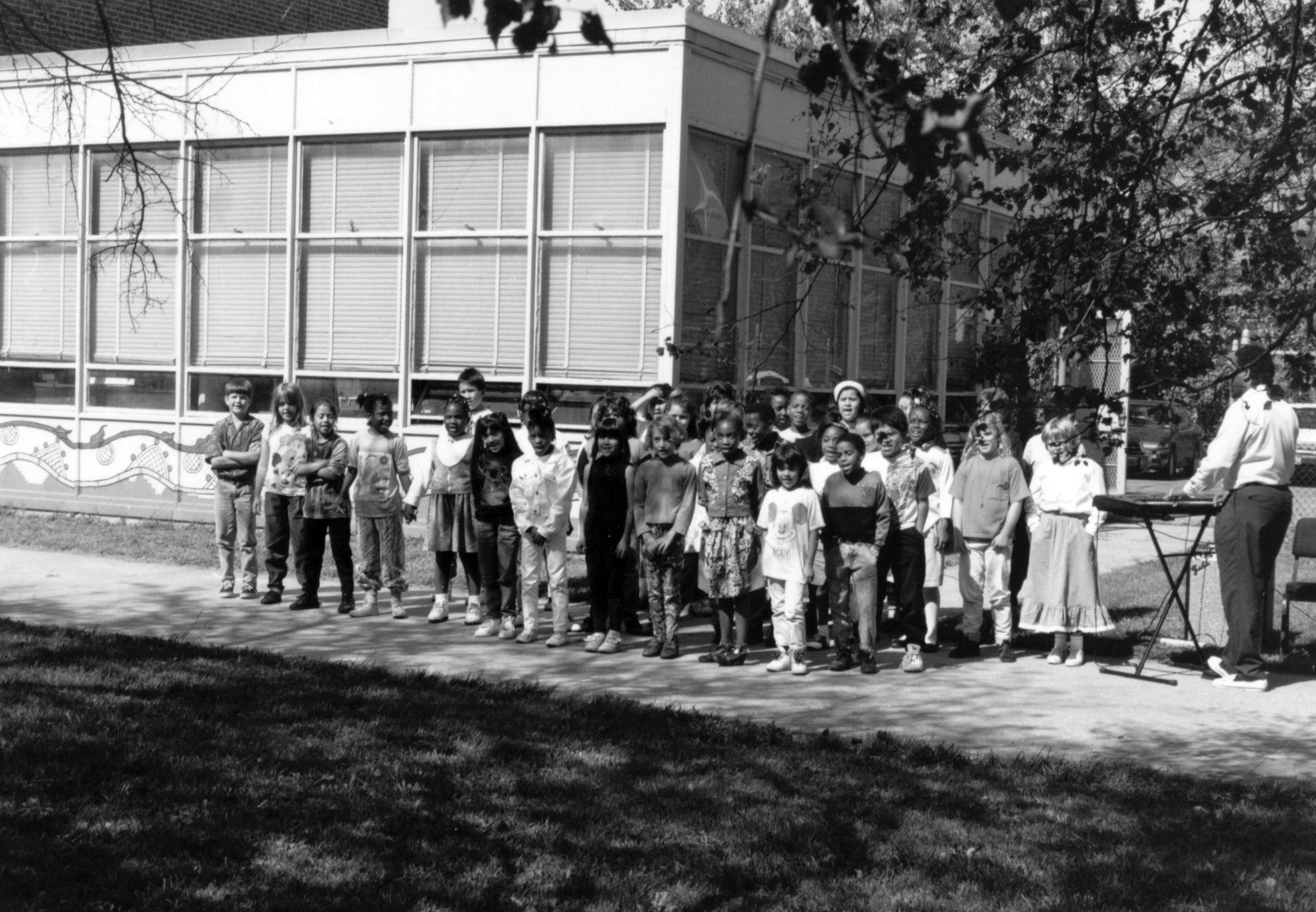 A group of school children standing outside of a building