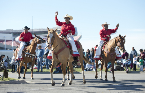 Three men on horseback riding in a parade