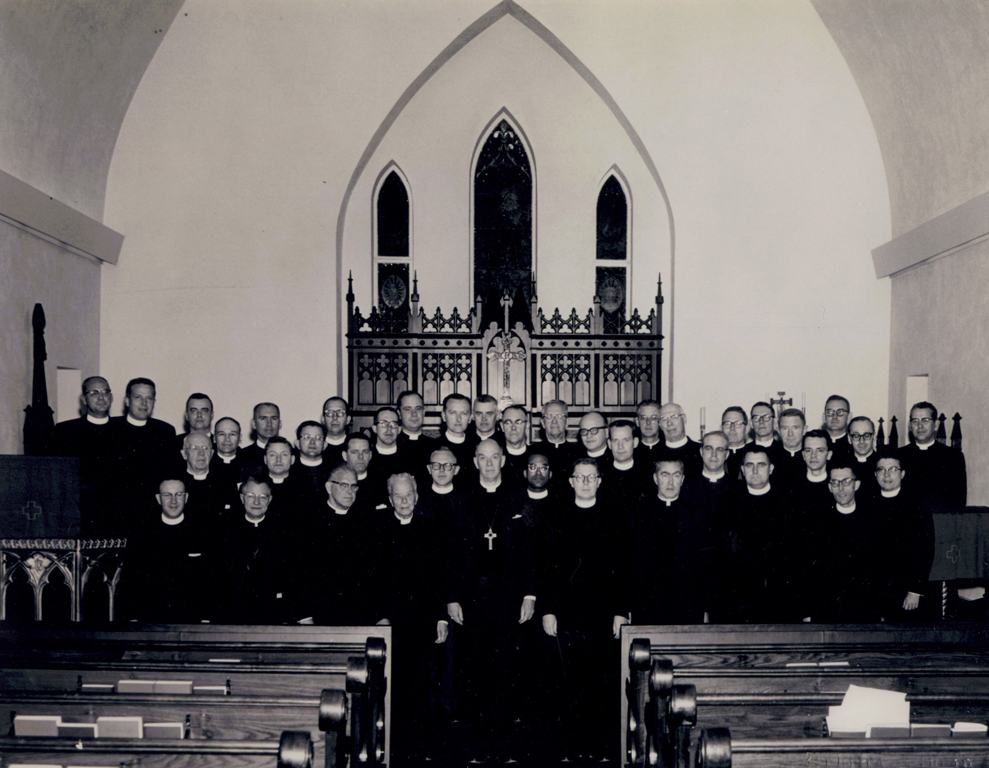 A gropu of clergymen standing in the sanctuary of a church.