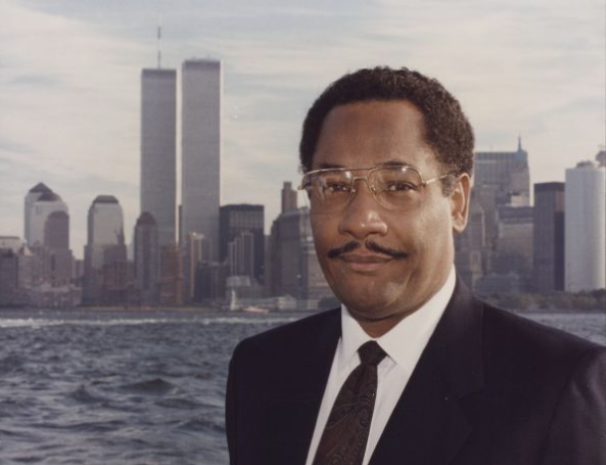 Lee Brown wearing a suit, in front of New York skyline