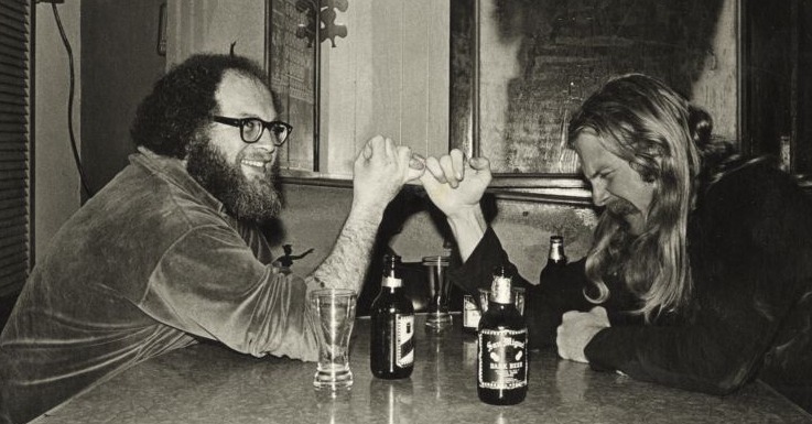 Two men playing thumb war at a table