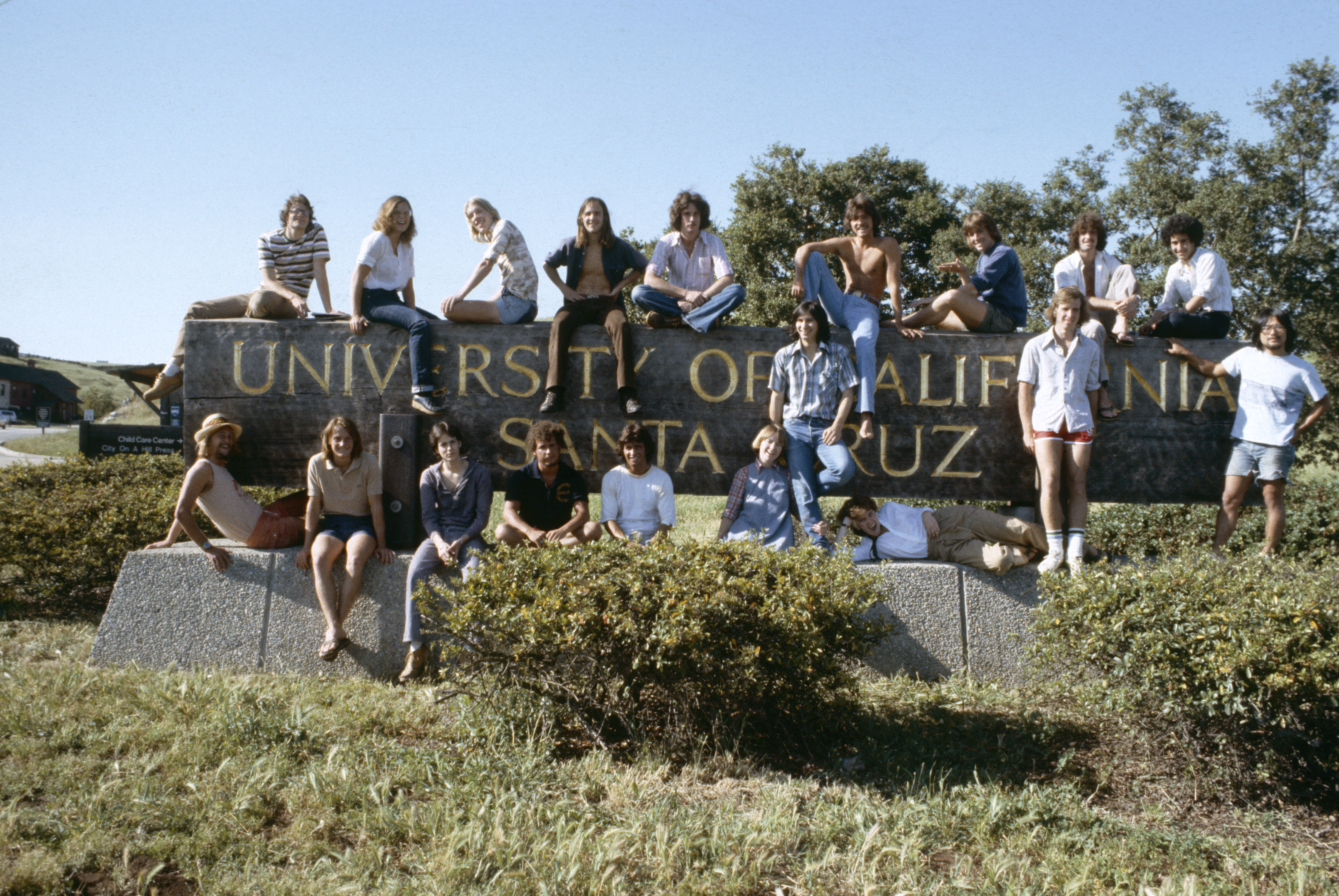 students standing in front of UCSC sign at base of campus